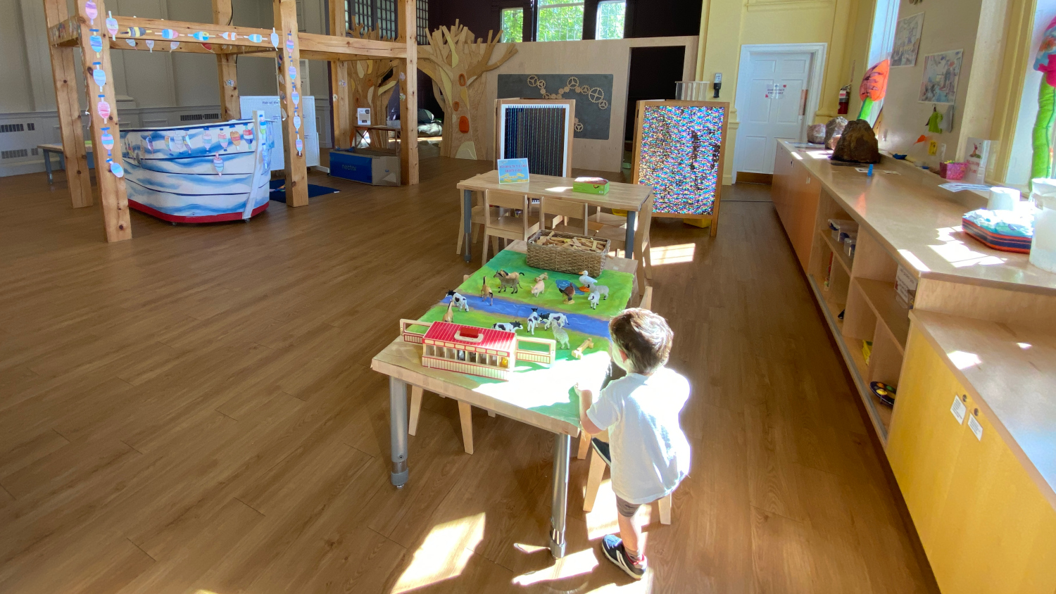 Child playing with farm toys at indoor playground in Maine.