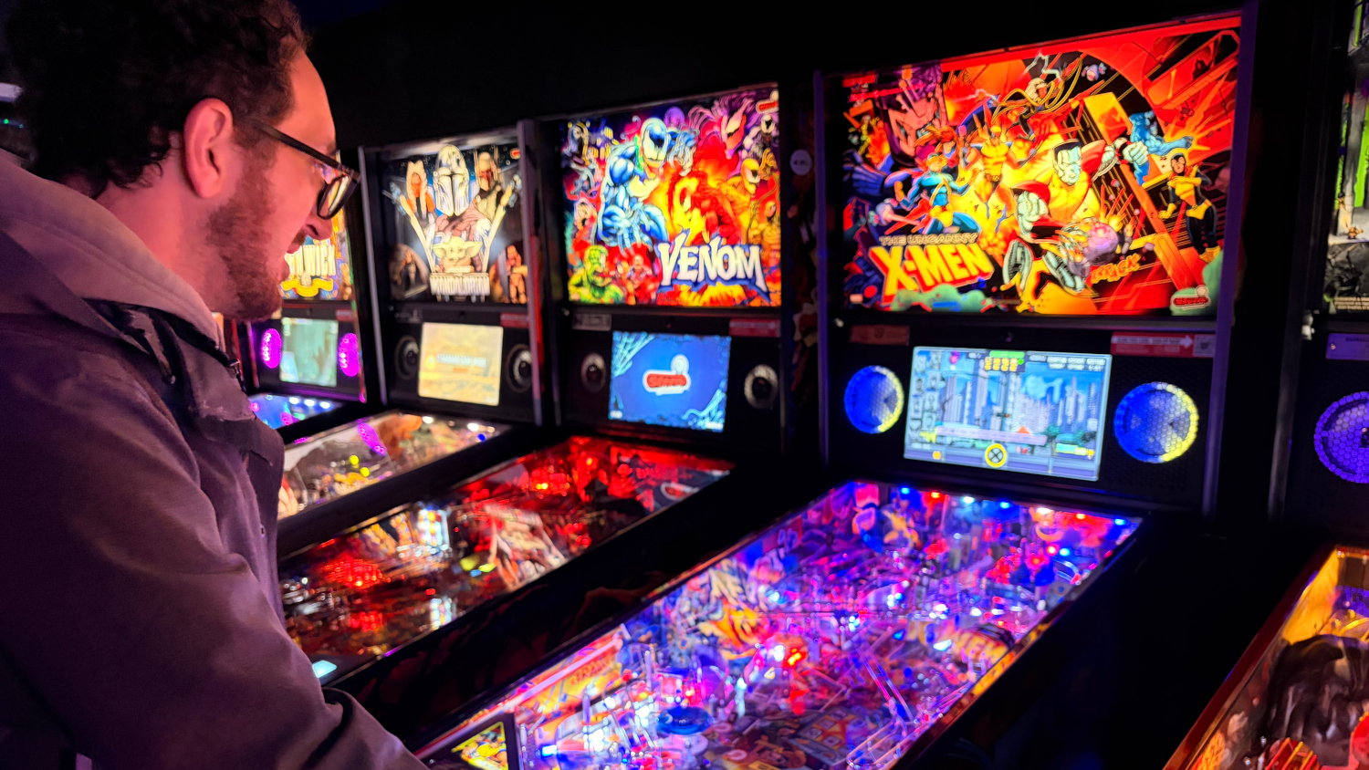 Man playing pinball game at Orono Arcade in Maine.