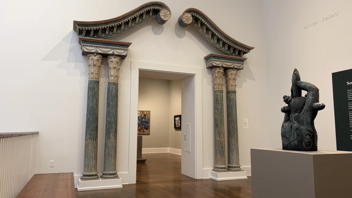 Pillars and sculptures surrounded by white walls.