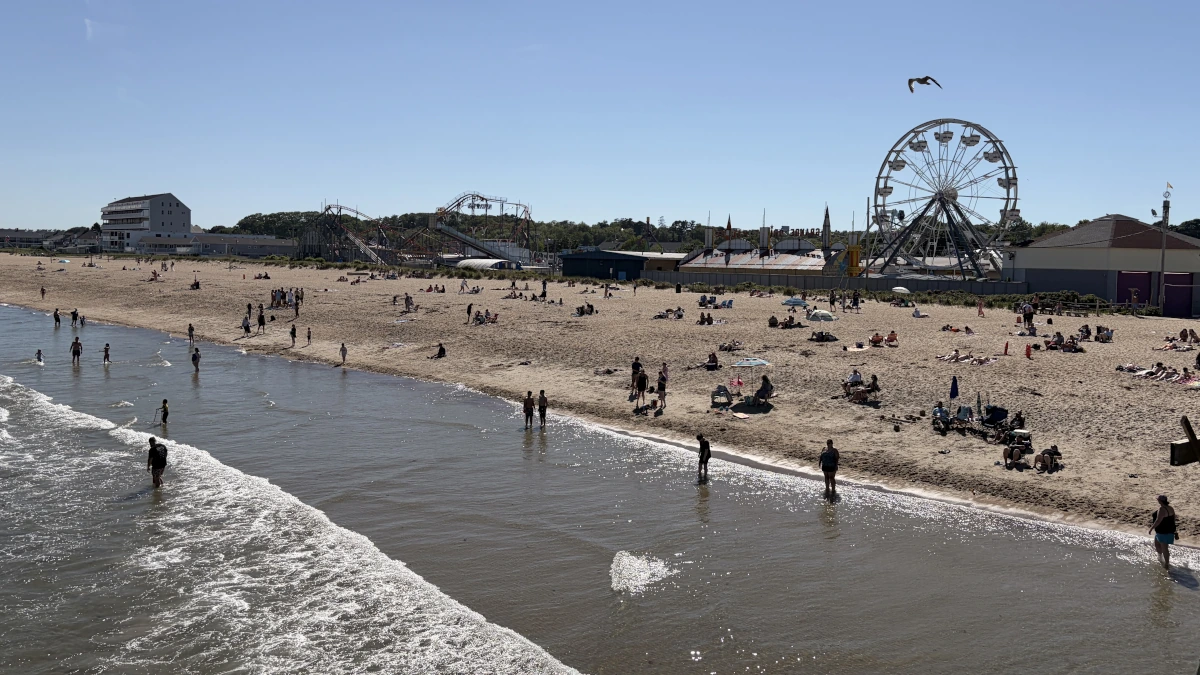 Old Orchard Beach Maine from above looking at the sand beach with dozens of people on it.